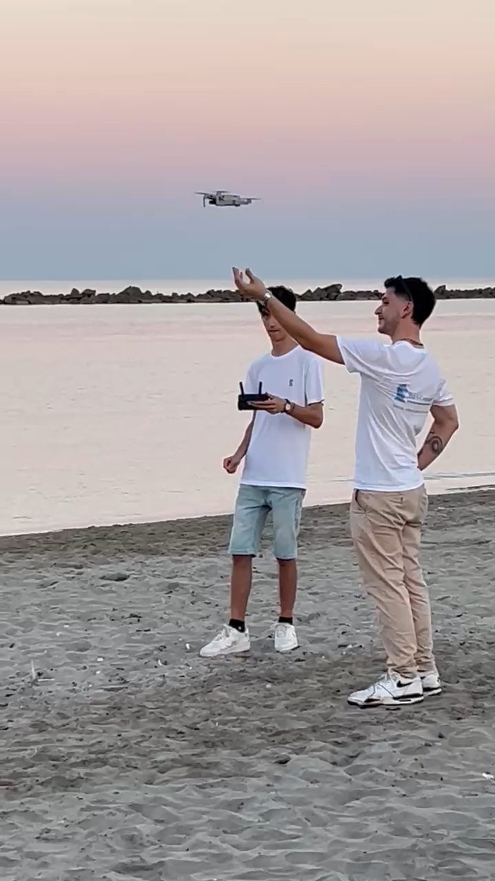 Drone in volo al tramonto sulla spiaggia durante una sessione di riprese aeree